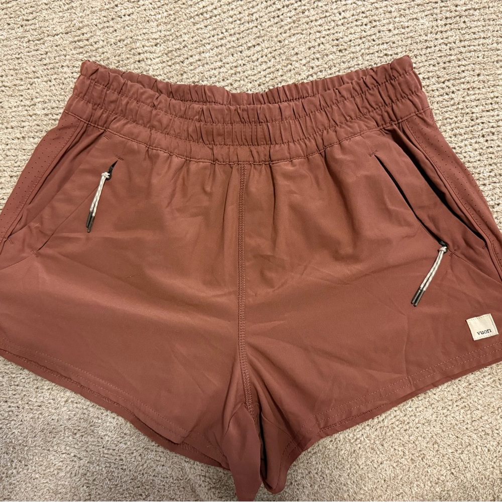 Vuori Women's Athletic Shorts in maroonish brown